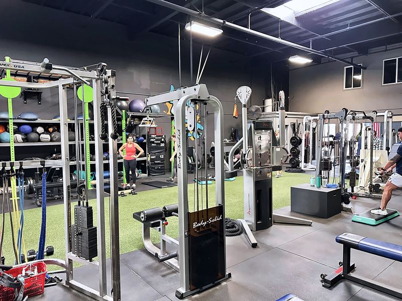 Cable stations, a ball shelf and benches inside the gym.